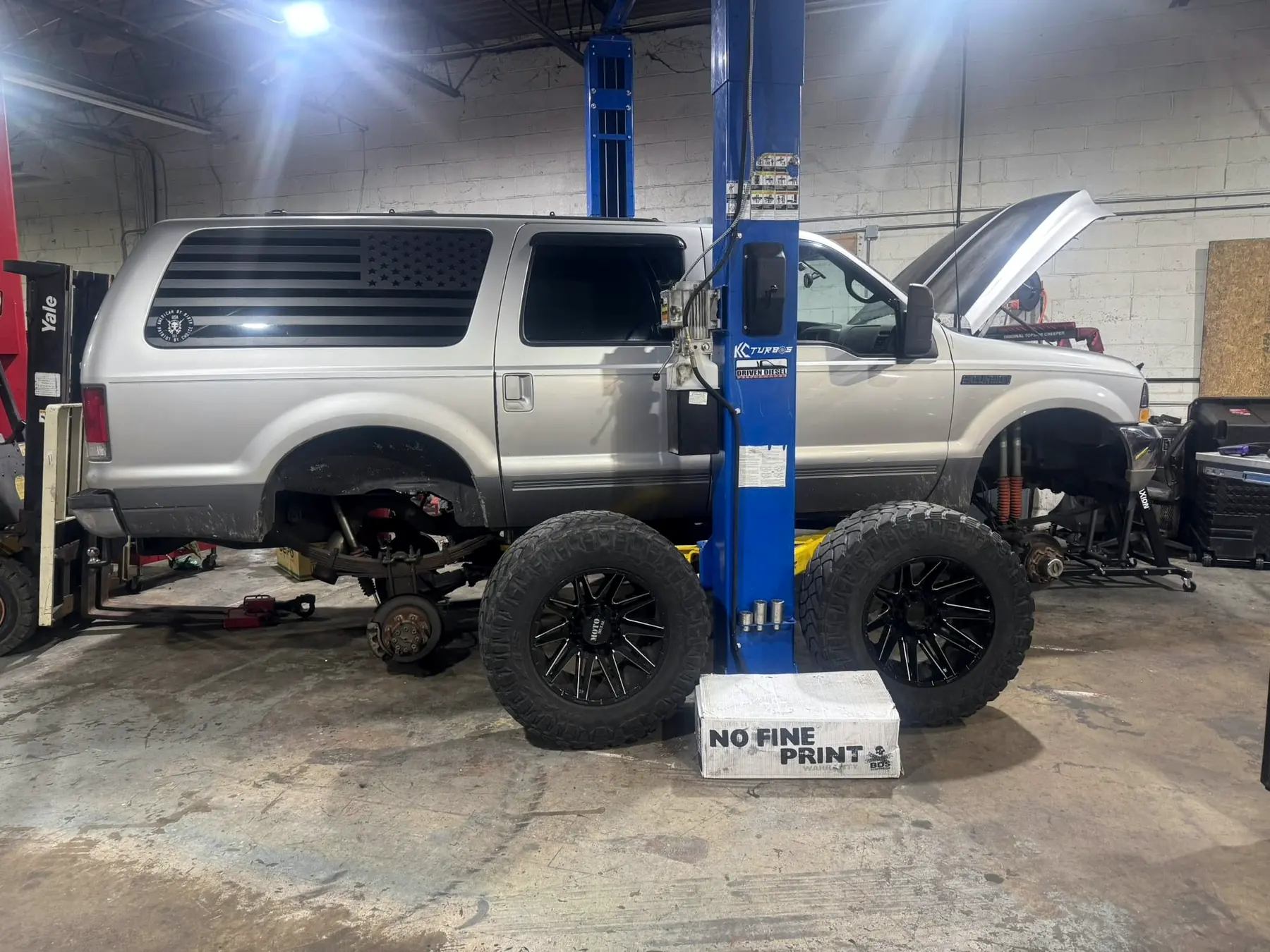 Lifted Ford Excursion on the two-post lift at CBS Diesel