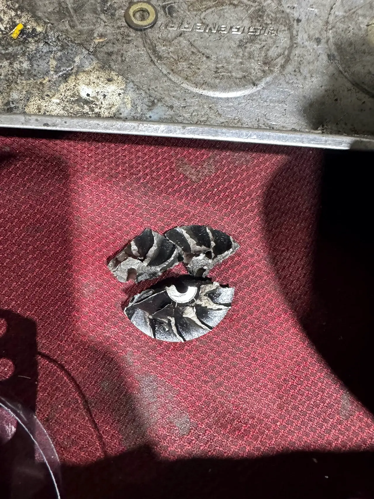 Fragments of a shattered turbocharger compressor wheel on the bench
